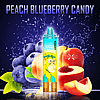 "An image of a vape pen with the label 'RandM Tornado 15000' featuring a cartoon monkey, placed in front of peaches and blueberries with the text 'Peach Blueberry Candy' at the top."