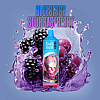 A colorful vape device labeled "R&M Tornado 9000" surrounded by splashing blueberries, blackberries, and raspberries against a purple background.