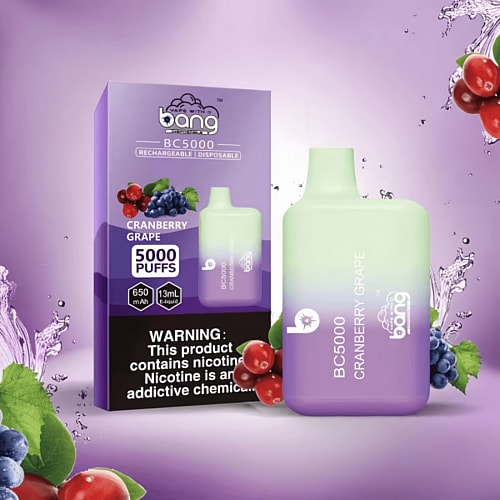 Bang BC5000 rechargeable disposable vape in cranberry grape flavor, featuring 5000 puffs, 650 mAh battery, and 13ml e-liquid capacity with a warning about nicotine addiction. The packaging and vape device are displayed against a purple background with images of cranberries and grapes.